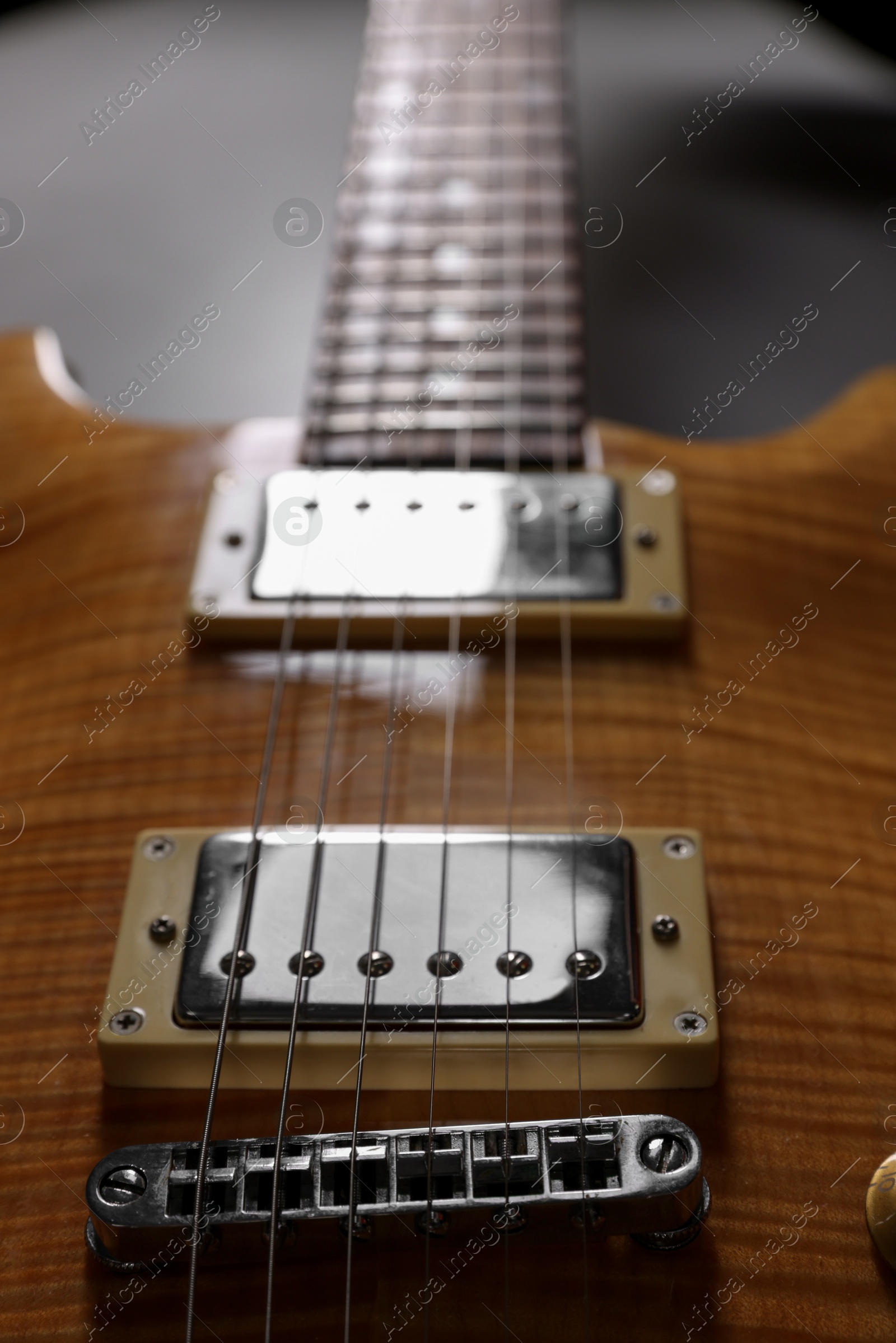 Photo of Modern electric guitar on grey background, closeup