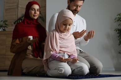 Muslim family praying on mat at home