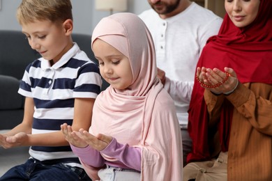 Photo of Happy Muslim family praying together at home