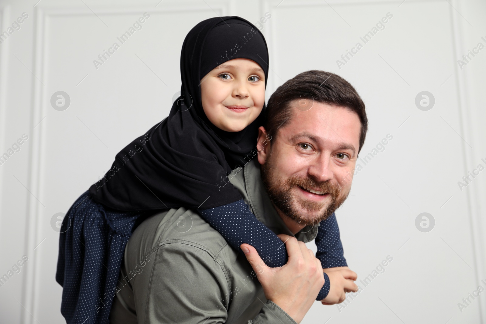 Photo of Muslim man and his daughter spending time together at home