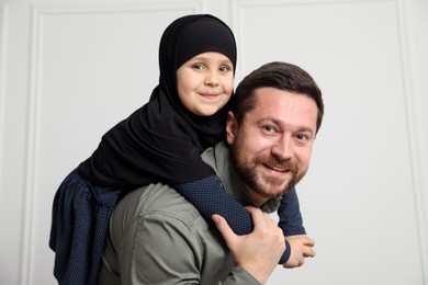 Photo of Muslim man and his daughter spending time together at home