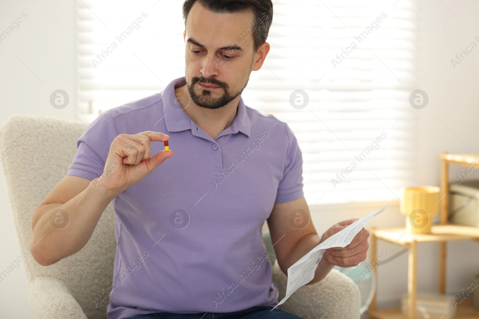 Photo of Man with pill and medical instruction at home