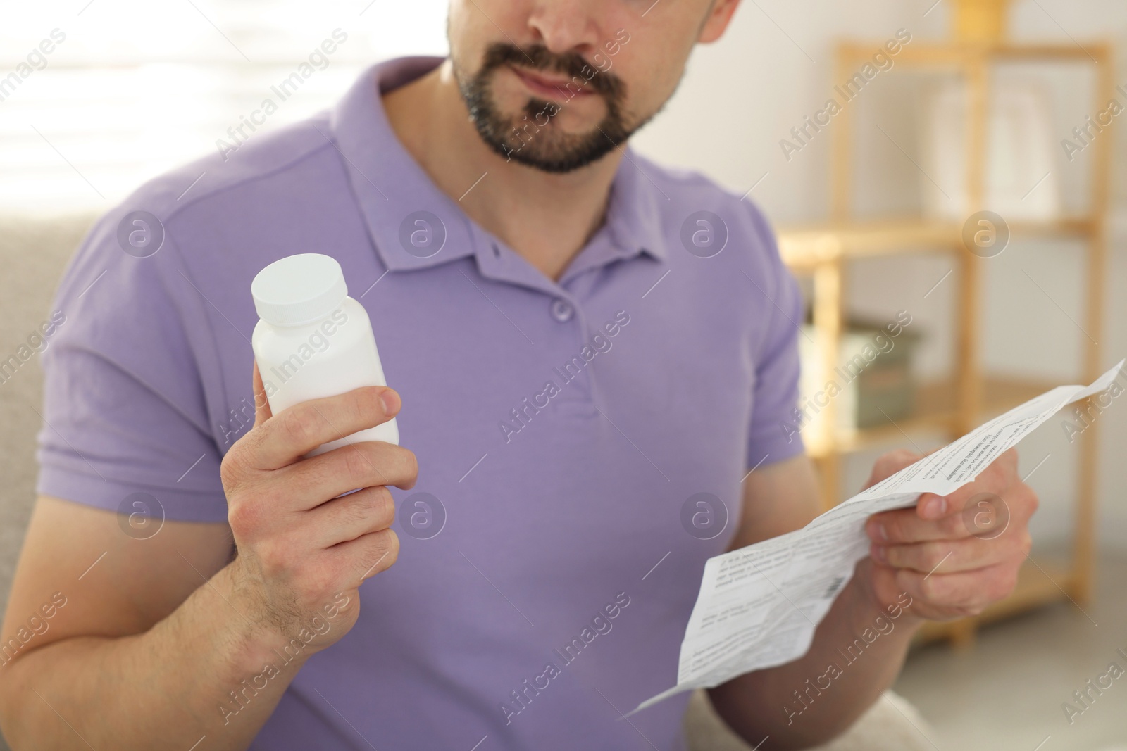 Photo of Man with pills and medical instruction at home, closeup