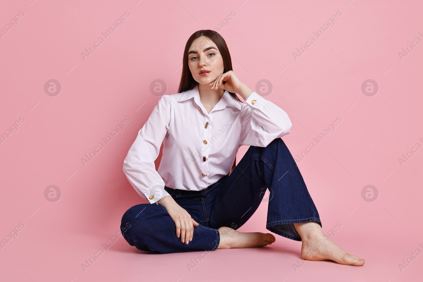 Photo of Beautiful young woman in stylish jeans on pink background