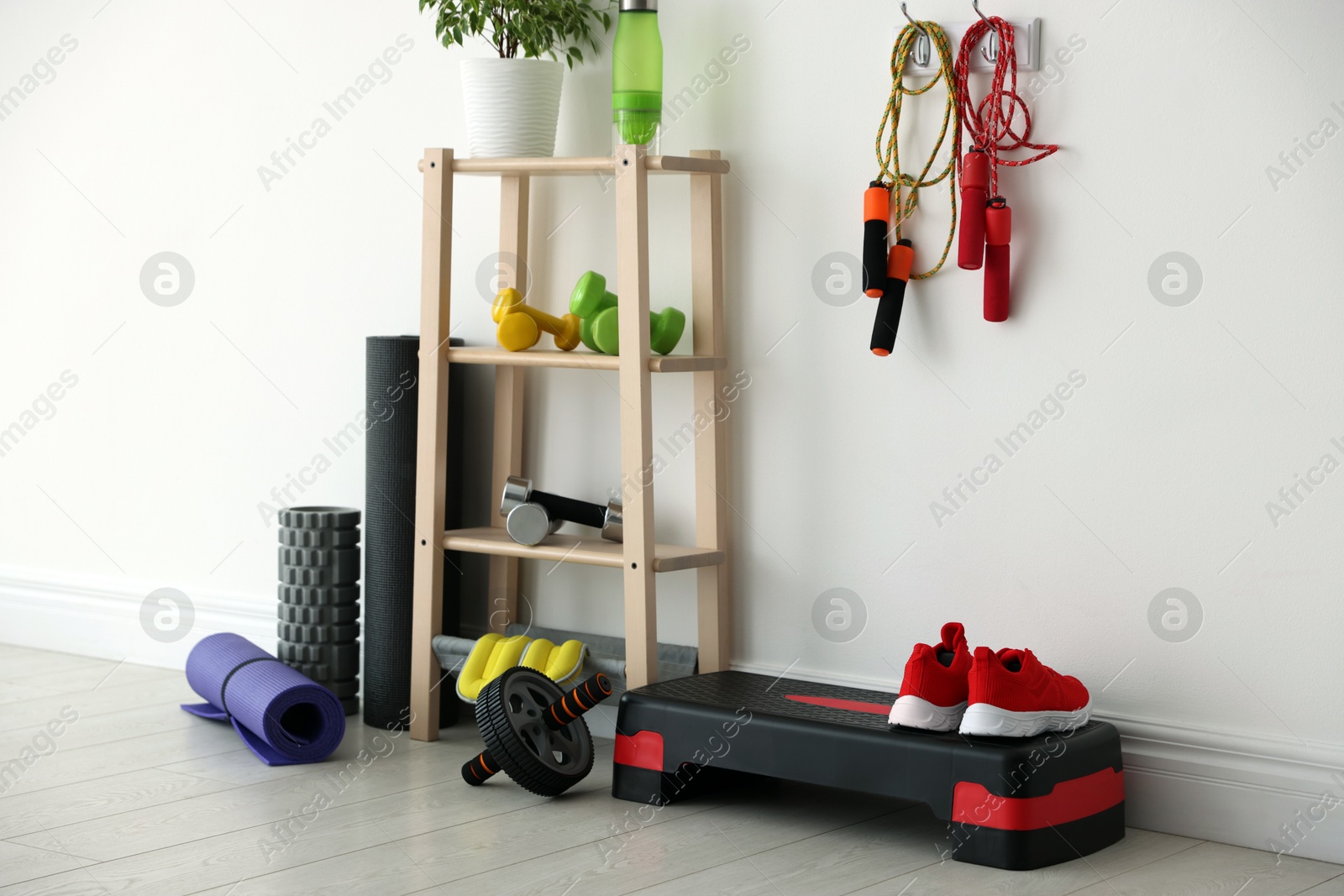 Photo of Different fitness equipment near white wall indoors