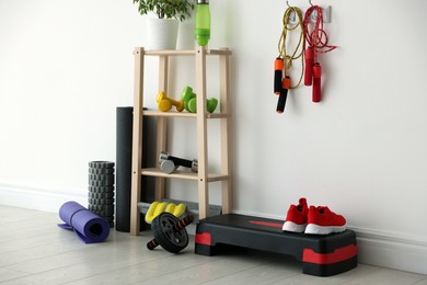 Different fitness equipment near white wall indoors