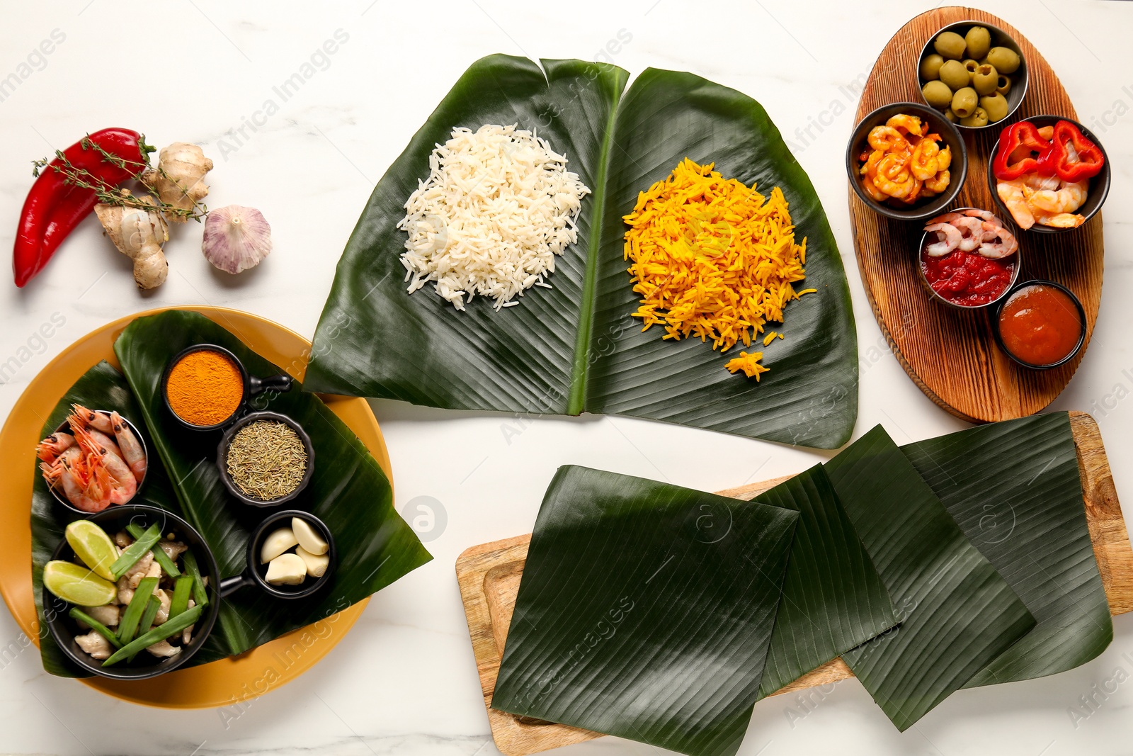 Photo of Cut banana leaves with different food, spices and sauce on white table, flat lay