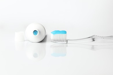 Photo of Toothbrush with toothpaste and tube on white background