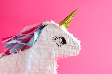 Photo of Bright pinata in shape of unicorn on pink background