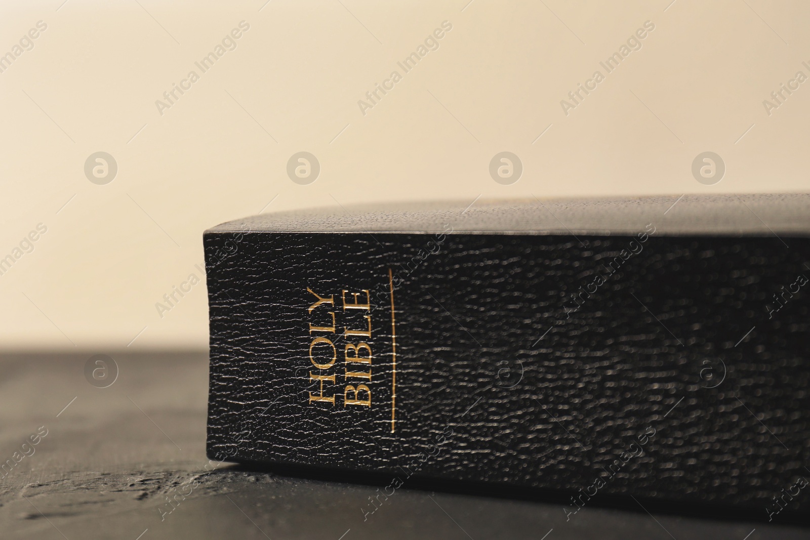 Photo of Hardcover Holy Bible in English language on black table, closeup