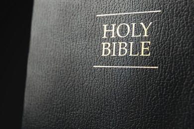 Hardcover Holy Bible in English language on black background, closeup