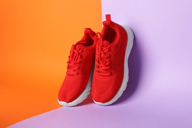 Photo of Pair of stylish red sneakers on color background