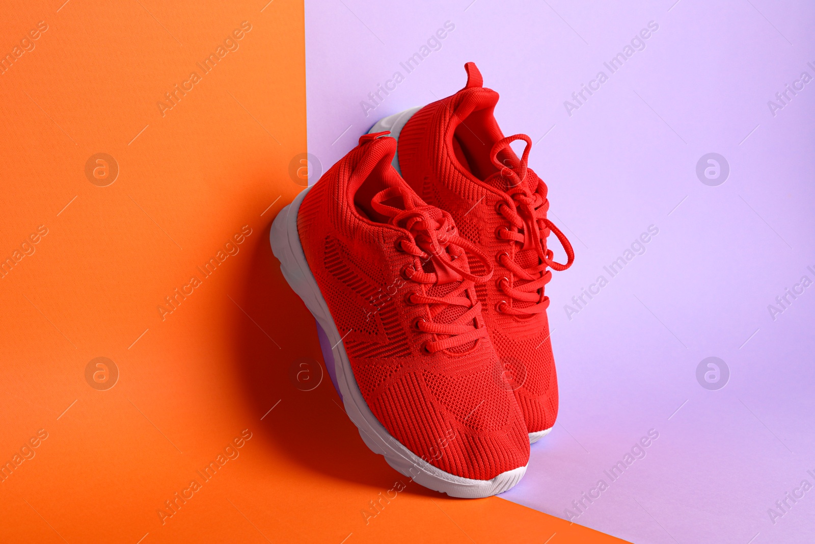 Photo of Pair of stylish red sneakers on color background