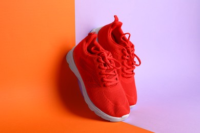 Photo of Pair of stylish red sneakers on color background