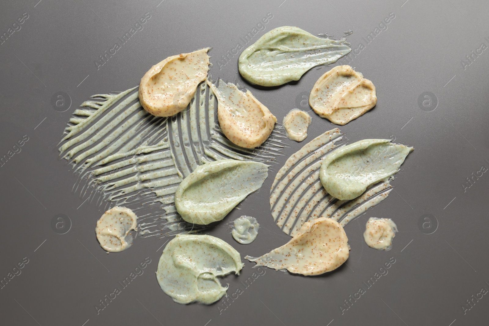 Photo of Samples of body scrubs on grey background, flat lay