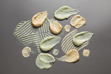 Samples of body scrubs on grey background, flat lay