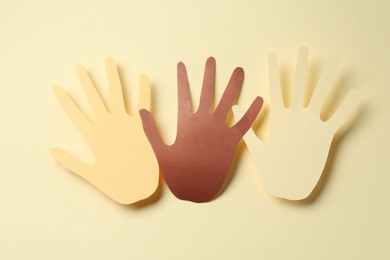 Photo of Stop racism. Paper palms of different colors on beige background, top view