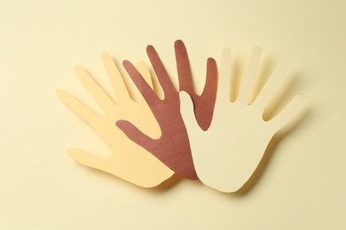 Photo of Stop racism. Paper palms of different colors on beige background, top view