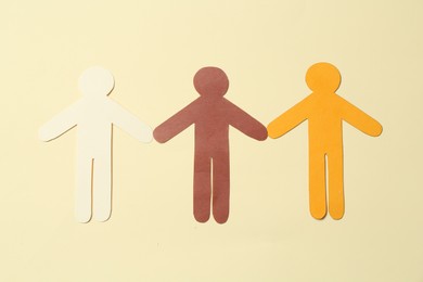 Photo of Stop racism. Paper human figures of different colors on beige background, top view