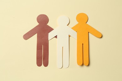 Photo of Stop racism. Paper human figures of different colors on beige background, top view