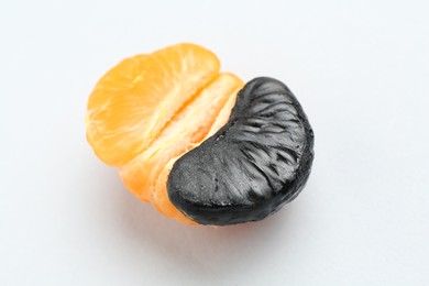 Photo of Stop racism. Half of tangerine with black piece on light background, closeup