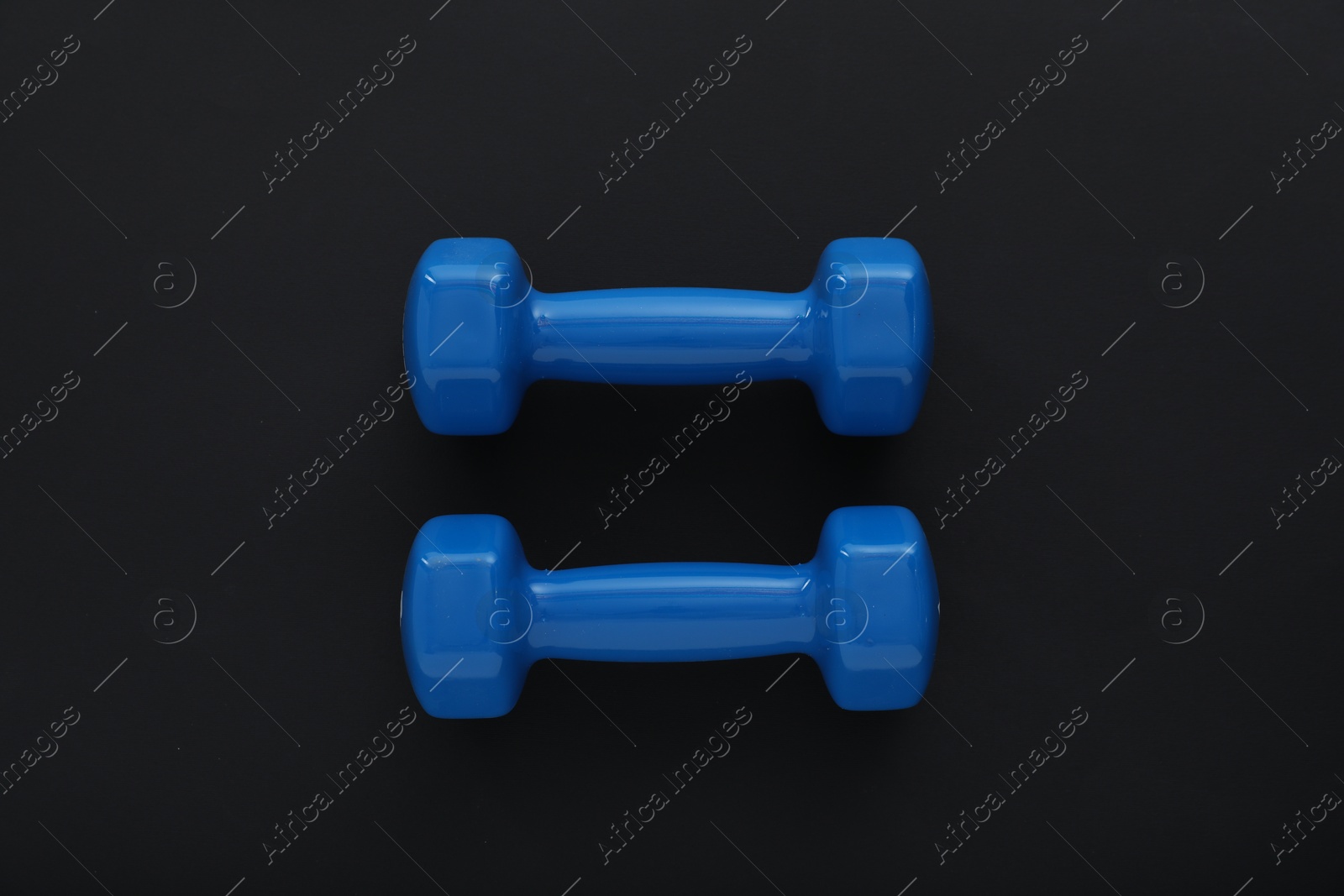 Photo of Dumbbells on black background, top view. Sports equipment