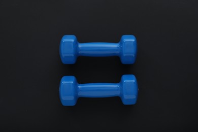 Photo of Dumbbells on black background, top view. Sports equipment