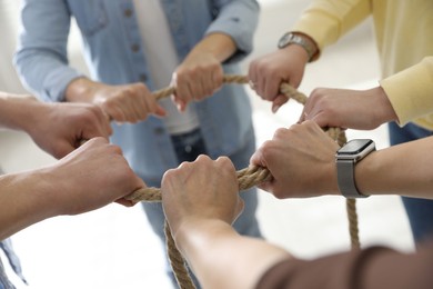 Unity concept. People holding rope together indoors, closeup