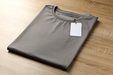 Photo of One blank t-shirt on wooden background, closeup. Mockup for design