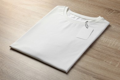 One blank t-shirt on wooden background, closeup. Mockup for design