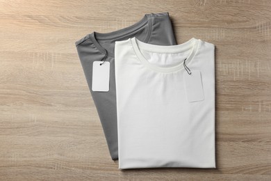 Photo of Blank t-shirts on wooden background, flat lay. Mockup for design