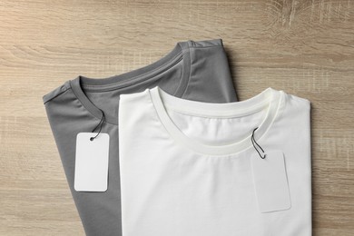 Blank t-shirts on wooden background, flat lay. Mockup for design