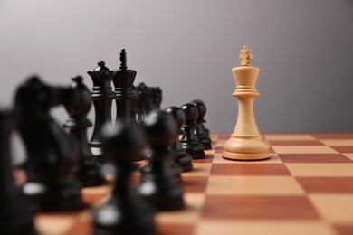 Photo of White king in front of other chess pieces on chessboard. Competition concept