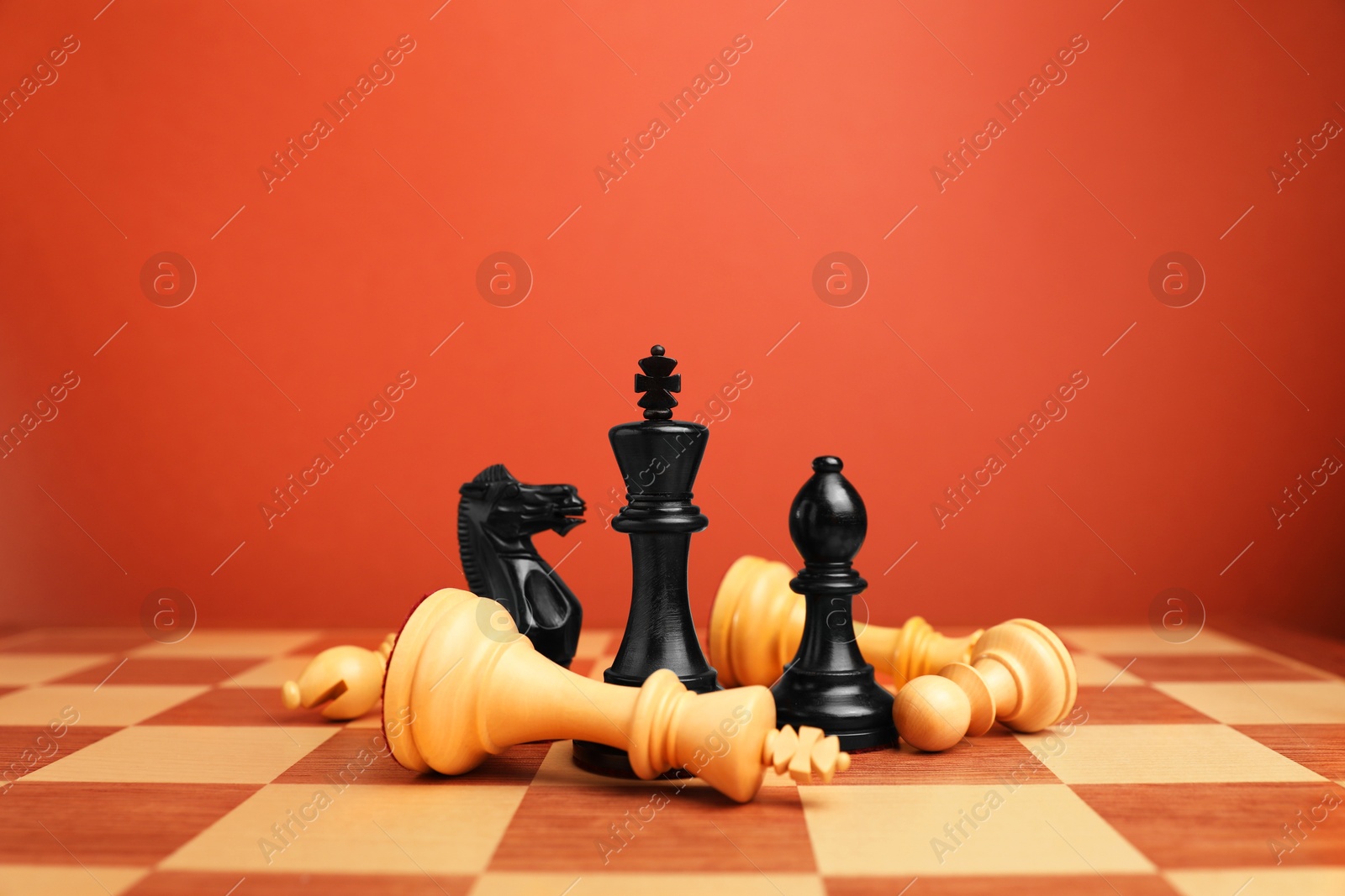 Photo of Black chess pieces among other fallen white ones on chessboard. Competition concept