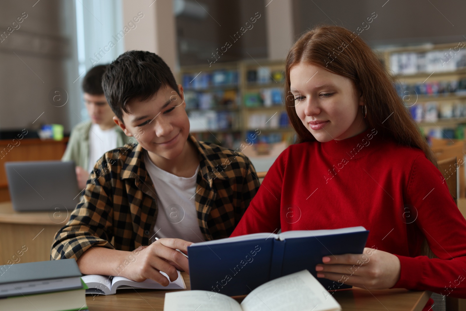 Photo of Students studying together at desk in public library