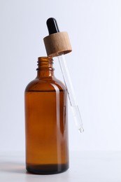 Photo of Bottle and pipette of serum on light table, closeup