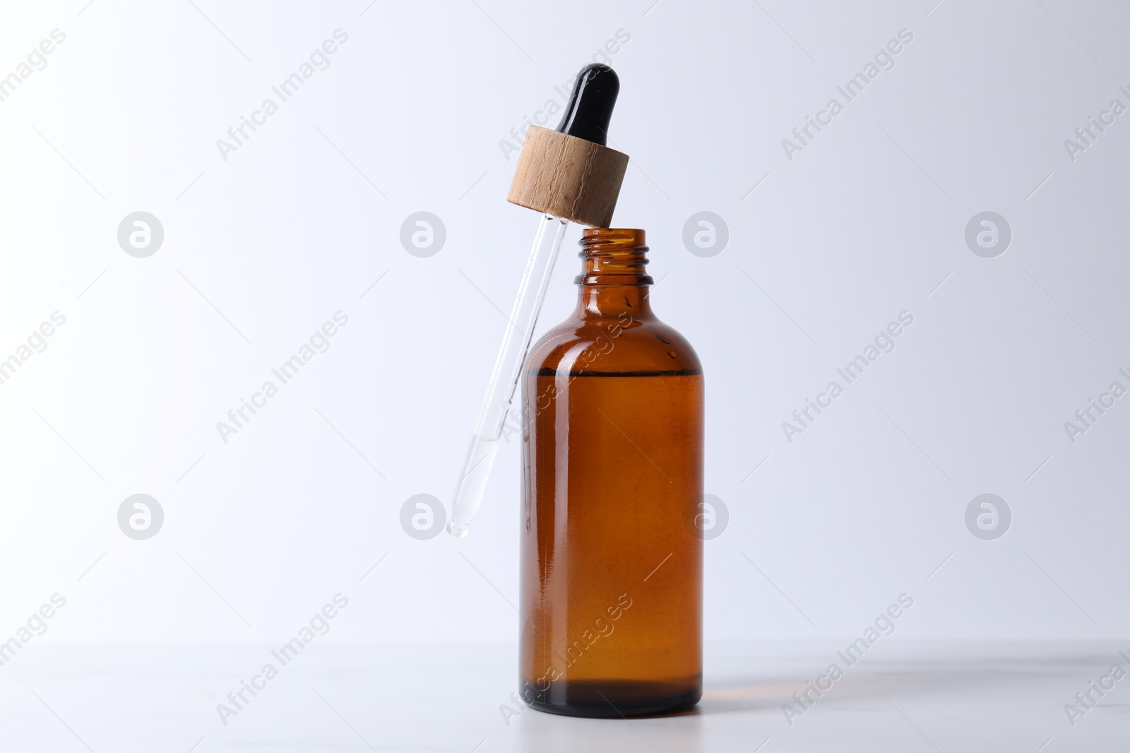 Photo of Bottle and pipette of serum on light table, closeup