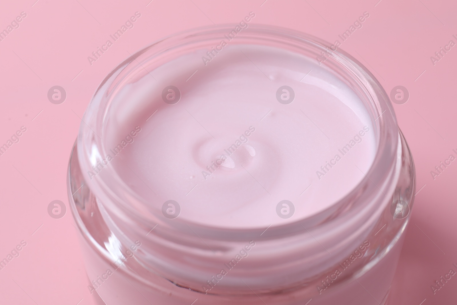 Photo of Jar of moisturizing cream on pink background, closeup