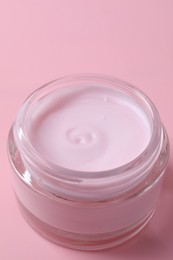 Photo of Jar of moisturizing cream on pink background, closeup