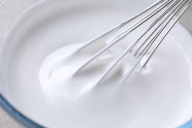 Photo of Whisking whipped cream in bowl, closeup view