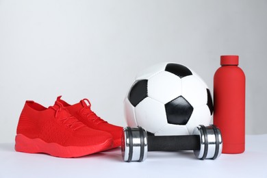 Photo of Sports equipment, sneakers and water bottle on white background