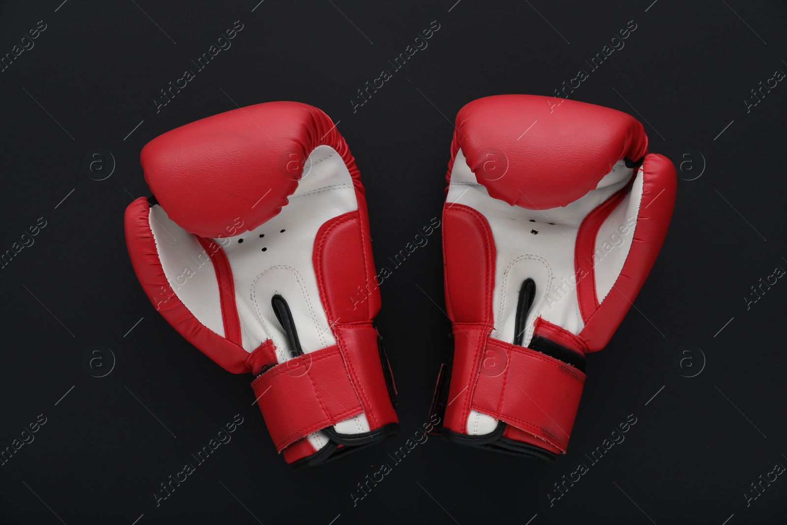 Photo of Boxing gloves on black background, flat lay. Sports equipment