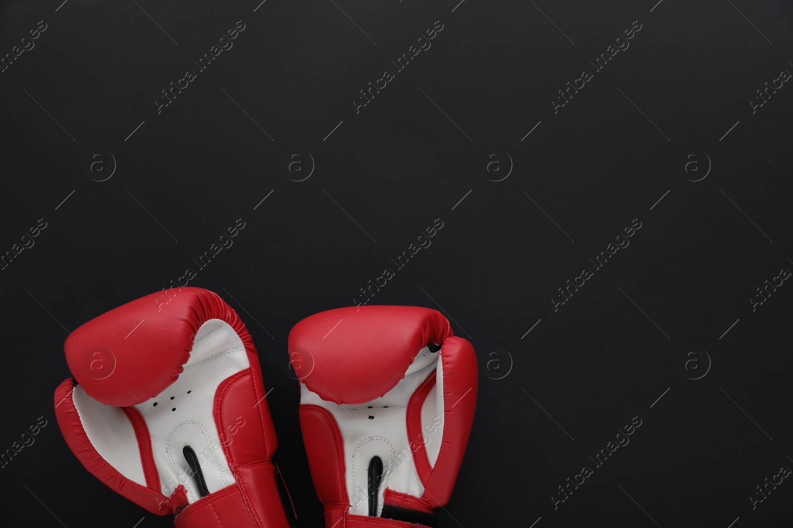 Photo of Boxing gloves on black background, flat lay and space for text. Sports equipment