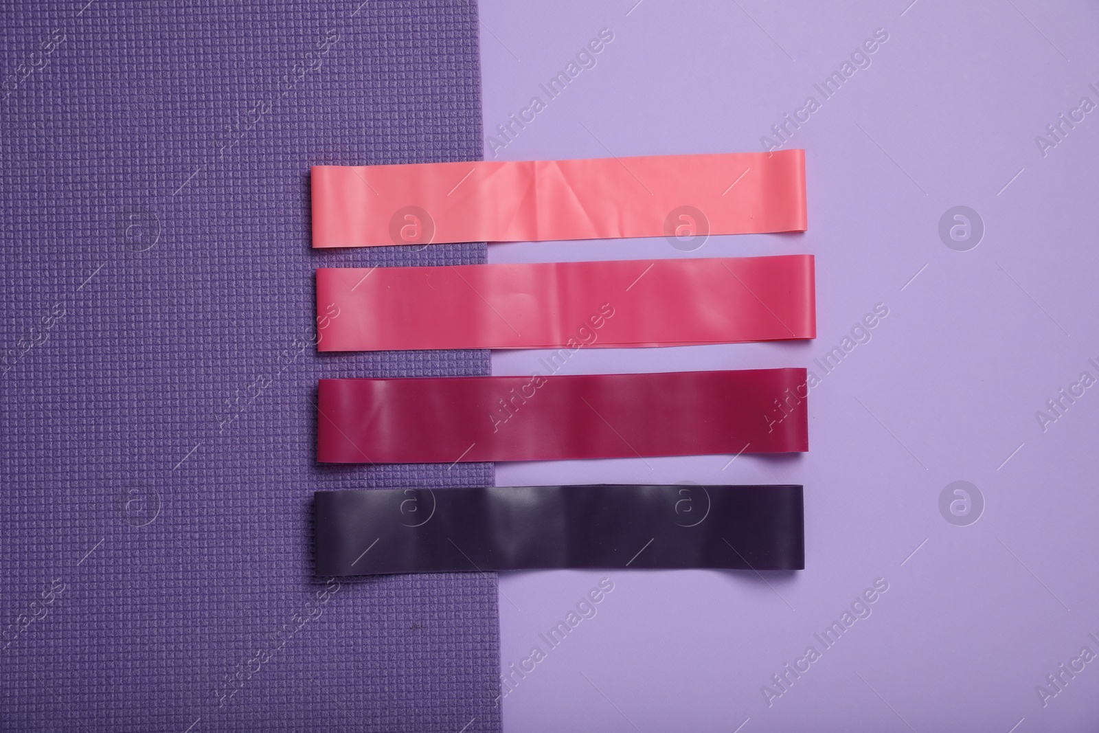 Photo of Many elastic bands on color background, flat lay. Sports equipment