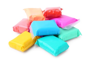 Photo of Different colorful play dough in packages isolated on white