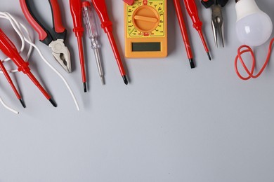 Photo of Different electrical tools on grey background, flat lay. Space for text