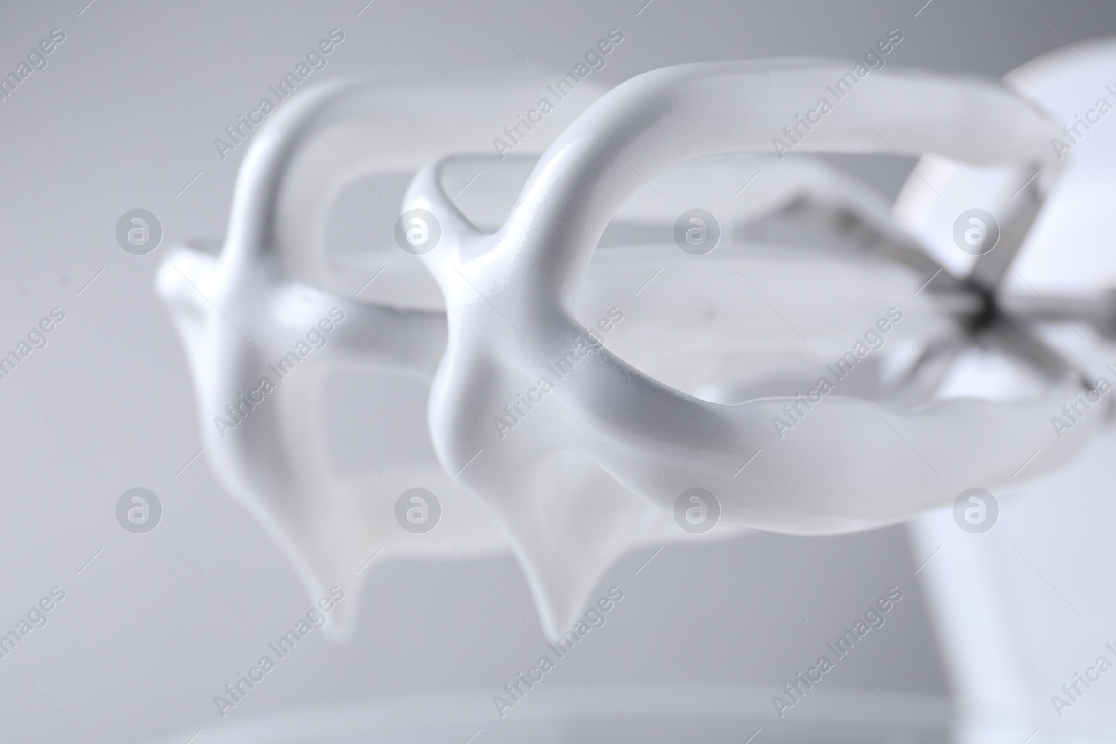 Photo of Hand mixer with whisks and whipped cream on grey background, closeup