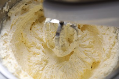 Photo of Mixing whipped cream in bowl with stand mixer, closeup