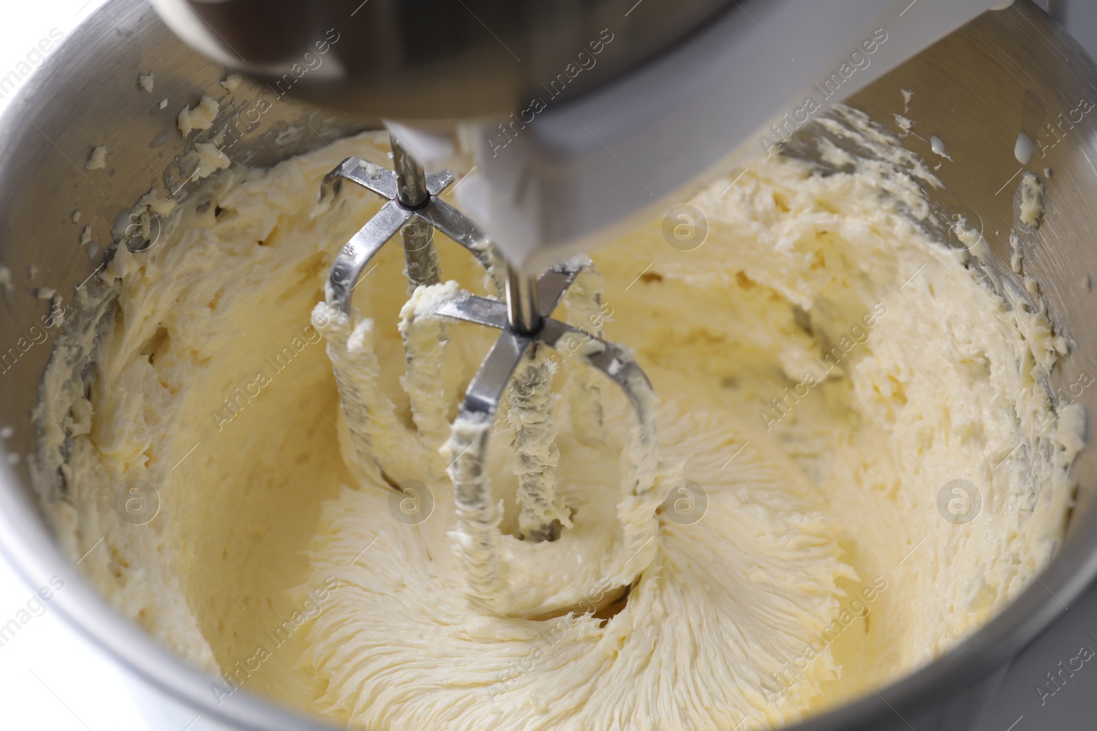 Photo of Mixing whipped cream in bowl with stand mixer, closeup