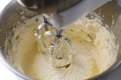 Photo of Mixing whipped cream in bowl with stand mixer, closeup